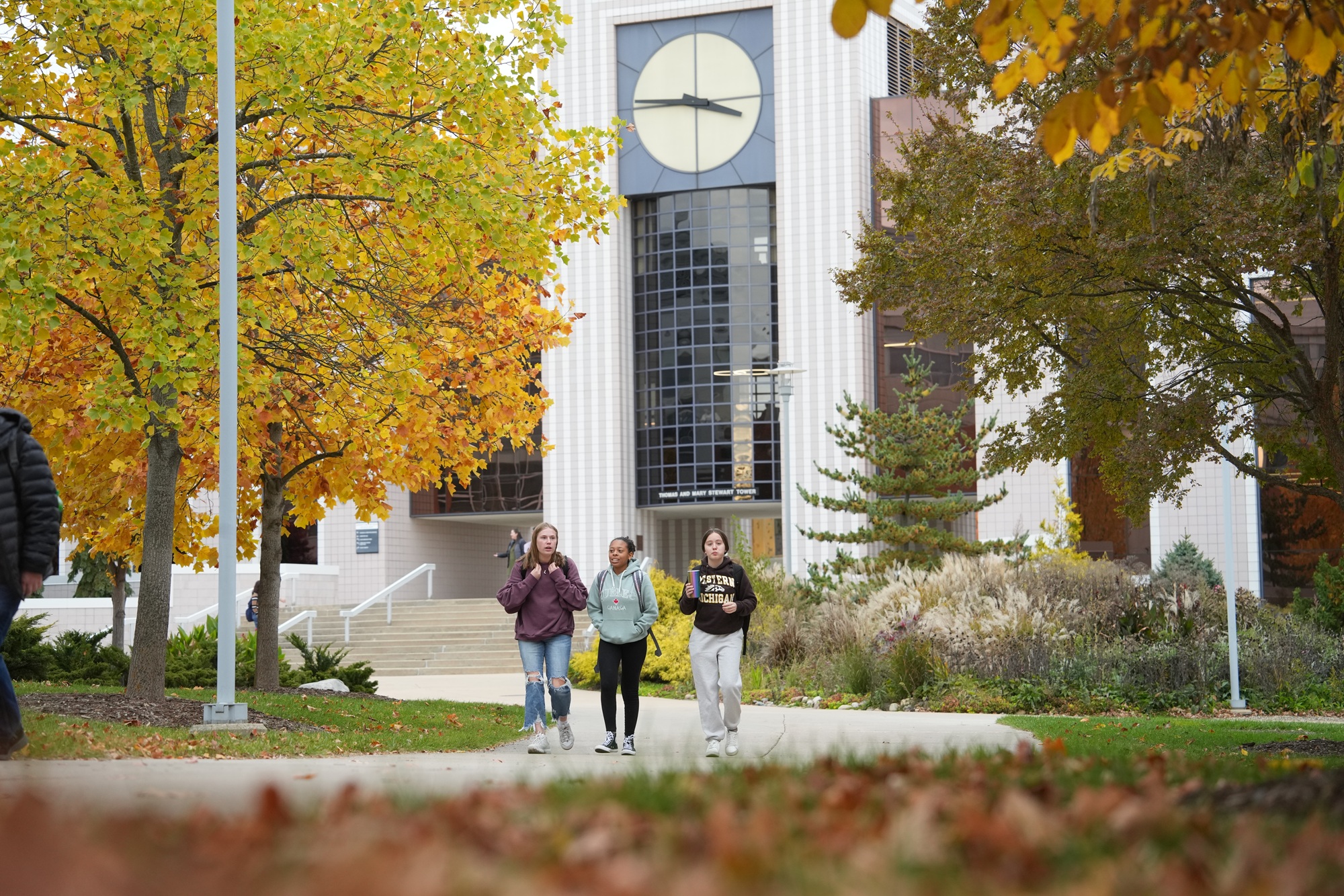 Students near clock tower in autumn